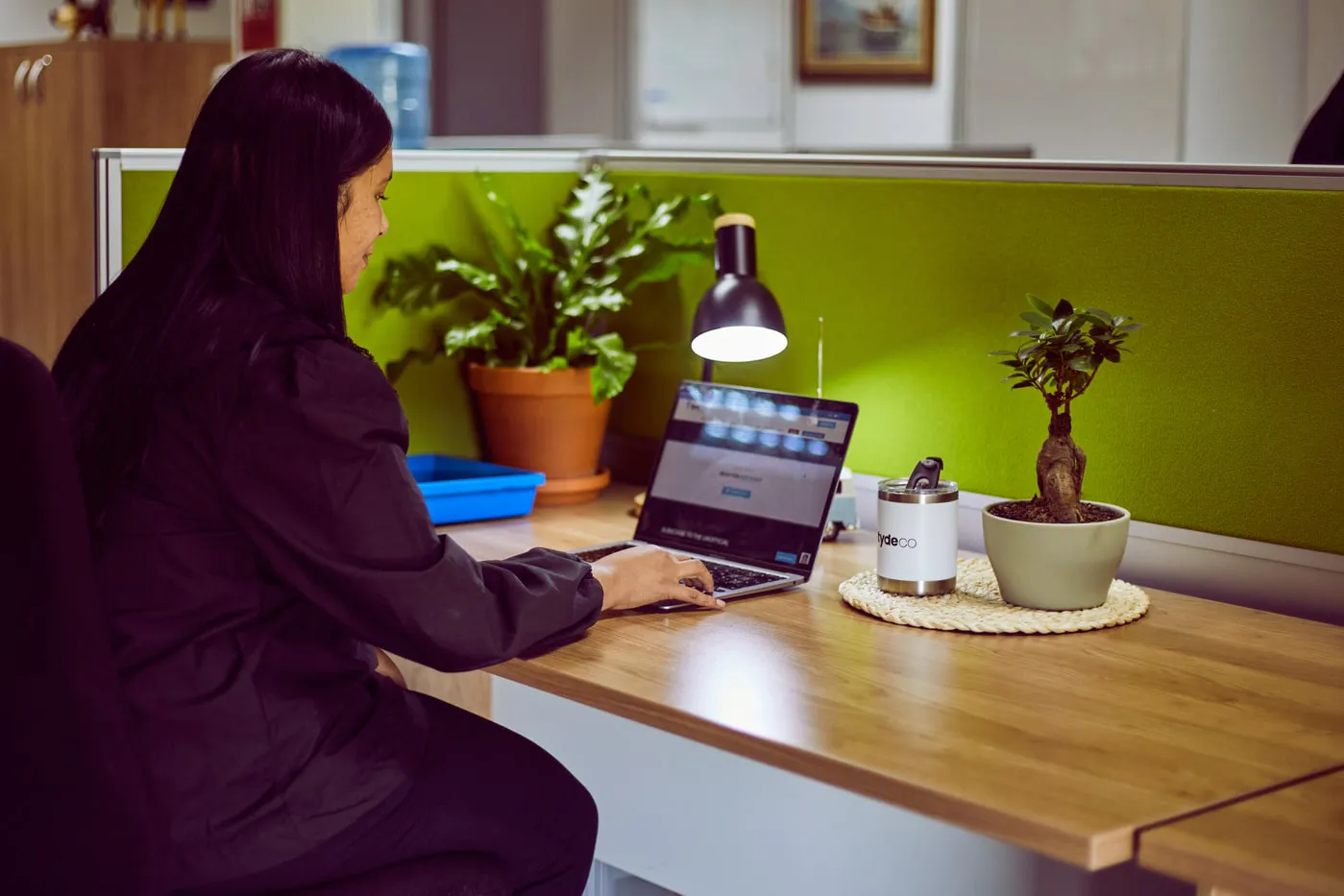 female worker sitting at her desk working on her laptop.