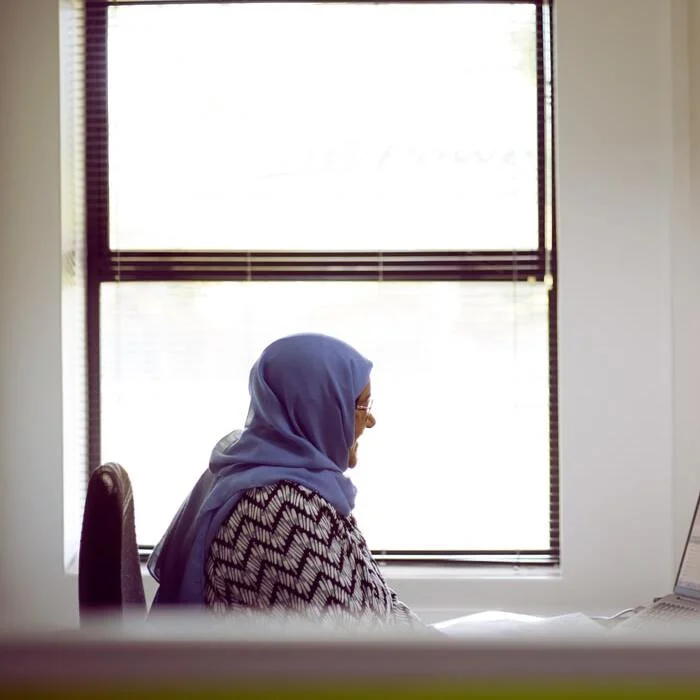 woman with a scarf sitting by a window