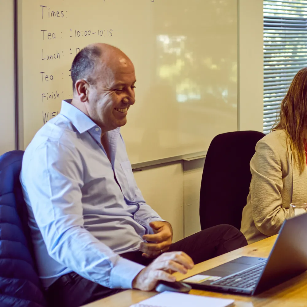 Health Medical Bookkeeping Services - man smiling sitting in a meeting