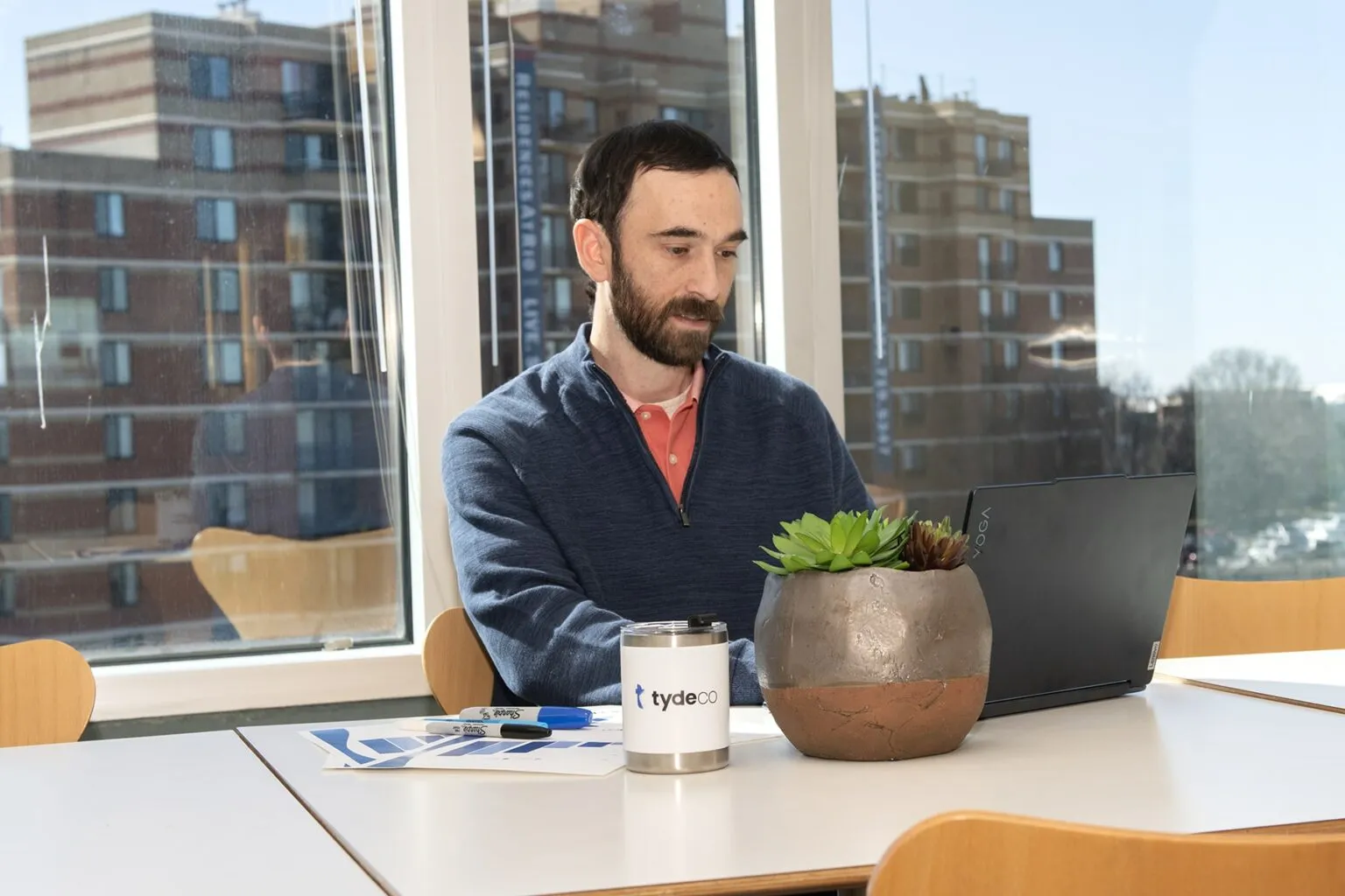 man in an office working on a laptop