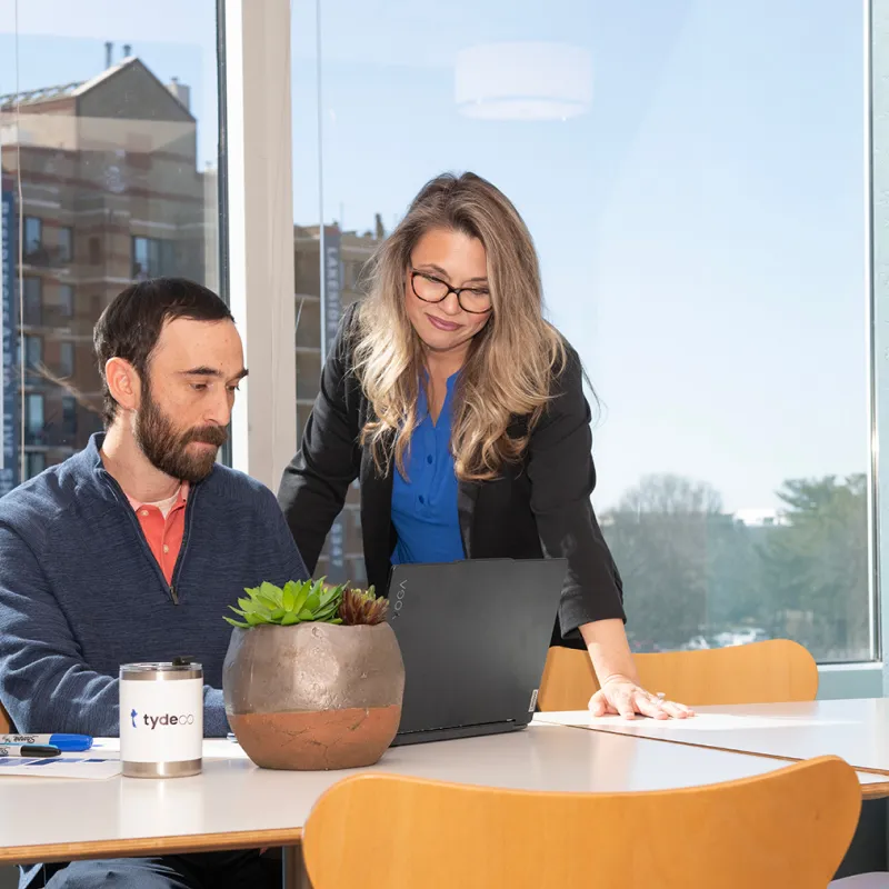 man and woman looking at a laptop screen in an office