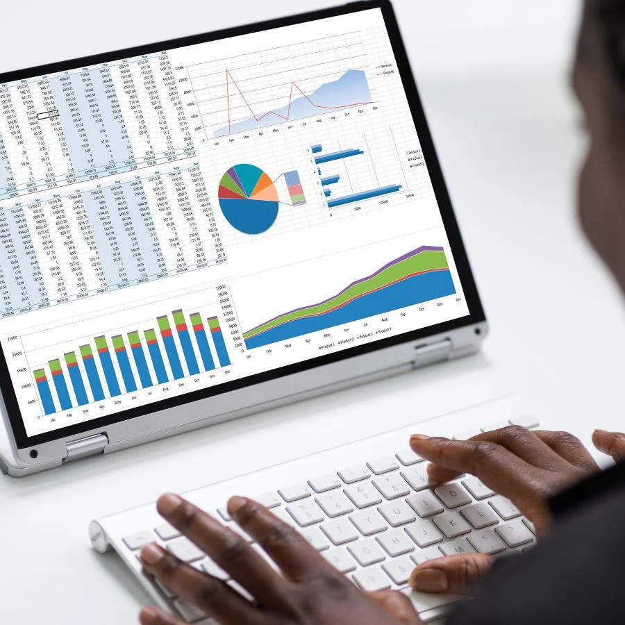 Trainer showing a colleague how to use Sage Intacct dashboards during a training session, with charts and graphs displayed on a laptop screen.