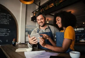 Two small business owners reviewing financial data on a tablet