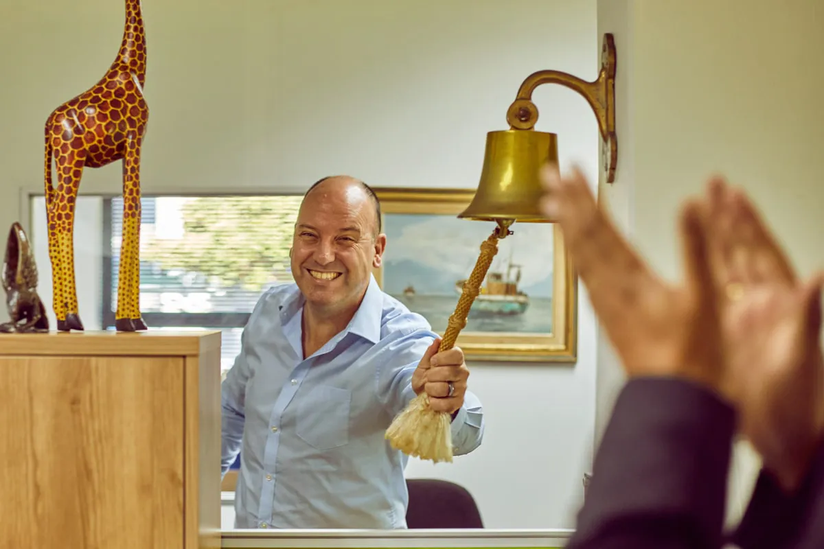 Staff member rings bell to confirm sale