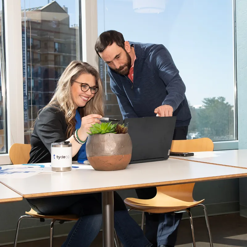 woman and man looking at a laptop having a discussion