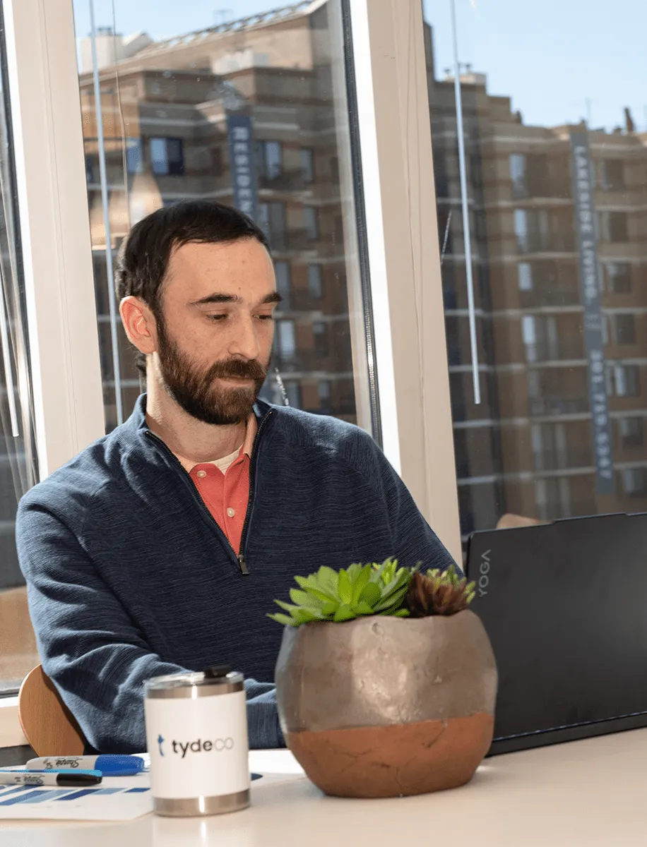 man sitting at his desk working on the laptops