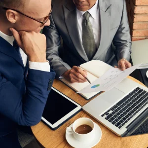 Law firm professionals reviewing accounts receivable reports and cash flow data on a laptop.